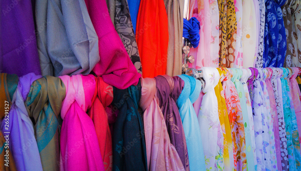 A variety of colorful fashion scarves for sale at a market