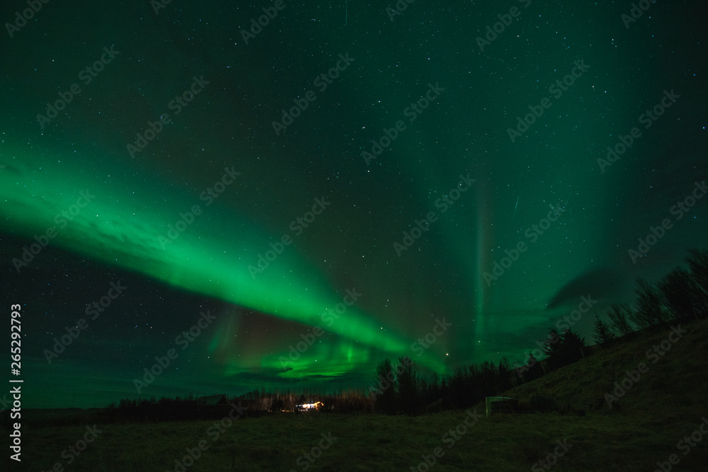Northern Lights in cold Icelandic nights, near waterfall Seljalandsfoss