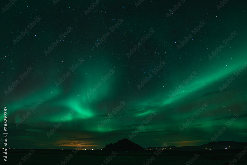 Northern Lights in cold Icelandic nights, near waterfall Seljalandsfoss