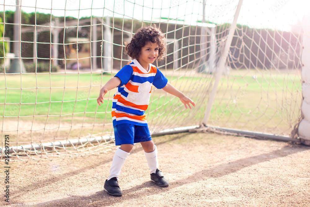 Little boy plays football outdoor. Children and lifestyle concept - obrazy, fototapety, plakaty 
