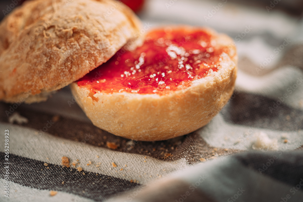 Sliced bread with strawberry jam on a tablecloth Sliced bread with strawberry jam on a tablecloth