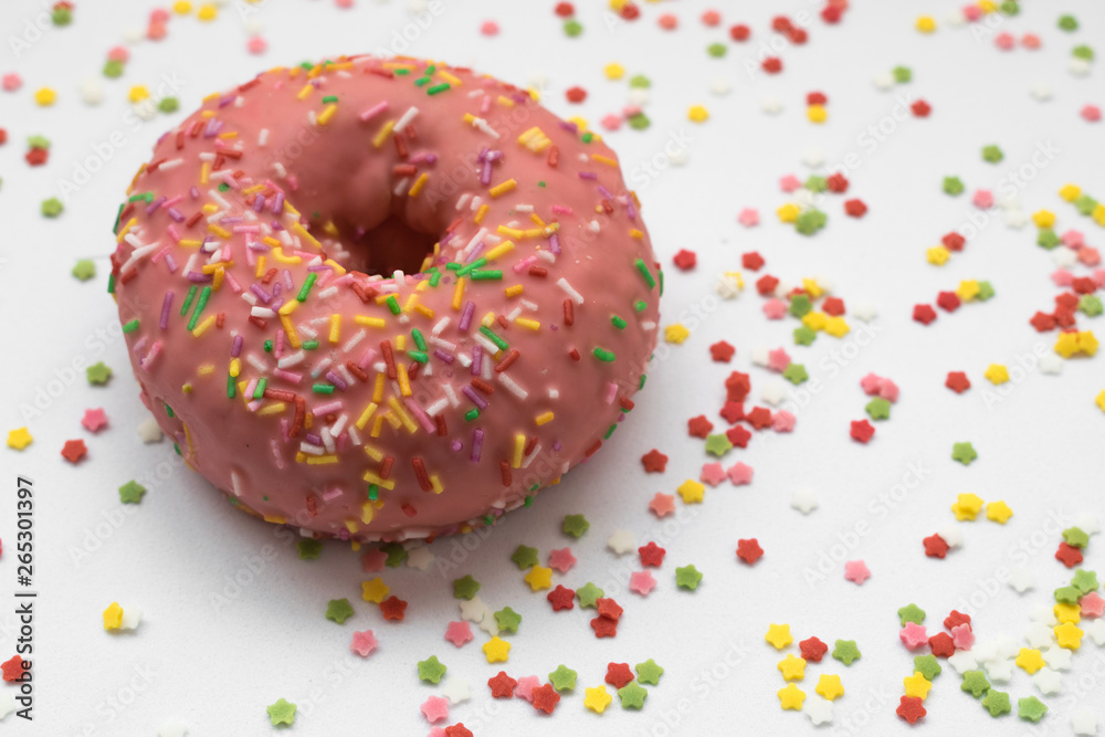 pink donut with sprinkles on a white background pink donut with sprinkles on a white background