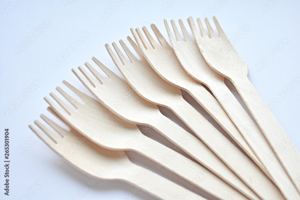 Wooden disposable forks on white background, eco friendly, natural, zero waste product, close up view, selective focus. Wooden disposable forks on white background, eco friendly, natural, zero waste product, close up view, selective focus.