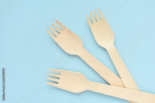 Natural  sustainable product  wooden disposable forks  zero waste concept  top view on blue background.
