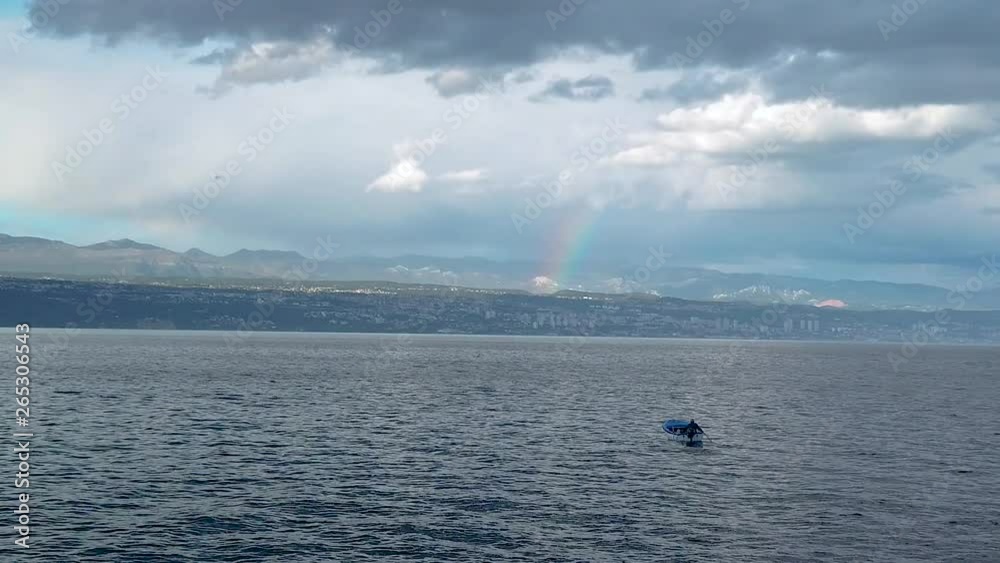Rainbow above small fishing boat in thunderstorm Rainbow above small fishing boat in thunderstorm