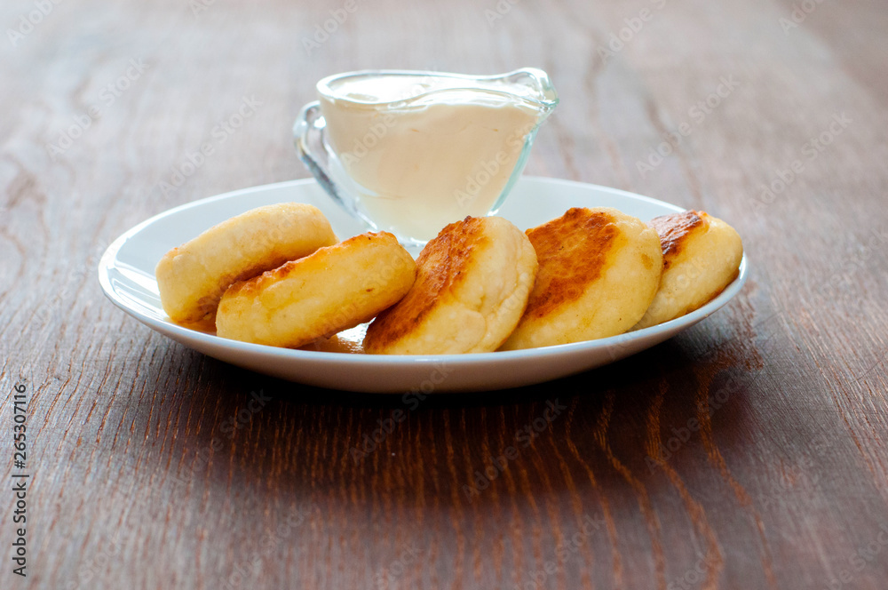 Fried cheesecakes with sour cream side view. For cafe or restaurant menu design.