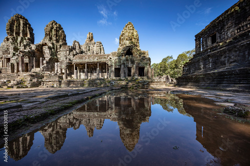Relections of the towers and beautiful face sculptures at the famous Bayon temple in the Angkor Thom temple complex, Siem Reap, Cambodia