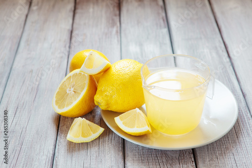 Freshly squeezed lemon juice on wooden table, copy space