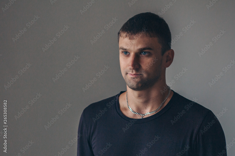 Obraz premium handsome man shows off gray clothes on grey background
