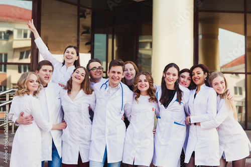 Education and health. general practitioner. A group of smart medical students in college. Friends interns on the background of the hospital. photo