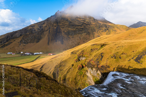 Skogafoss Waterfall in a Majestic Mountain Scenery on a Sunny autumn Day. Southern Iceland.