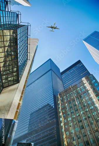 An airplane flies overhead Toronto skyscrapers. Skyscrapers in the financial district in downtown Toronto, Ontario, Canada.