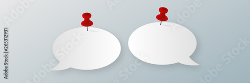 Paper speech bubbles with red pins on wall