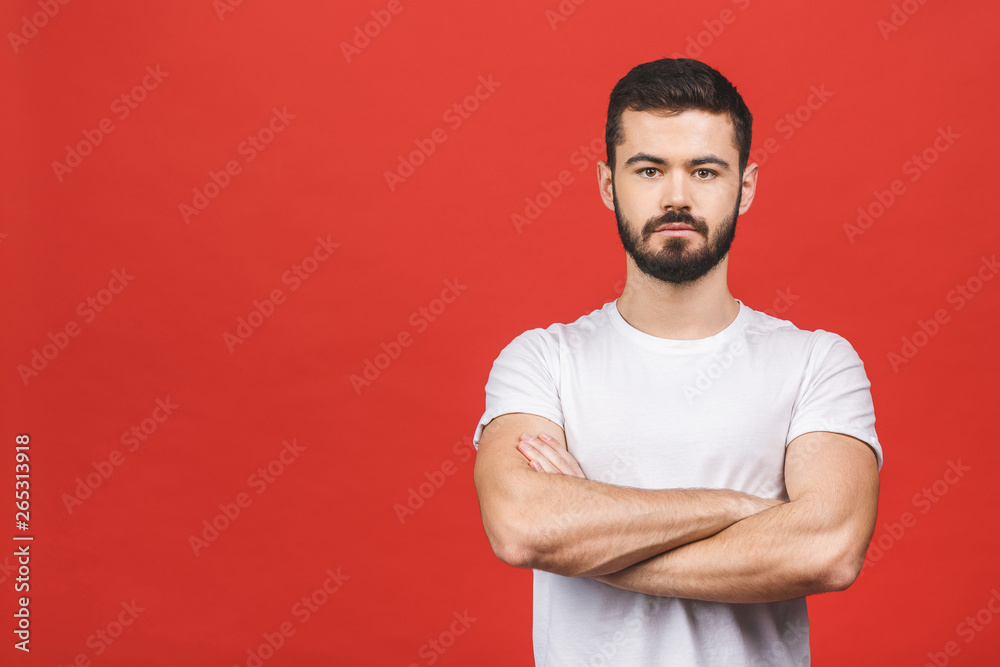 Portrait with copy space, empty place of stunning, sexy, smiling, cool man in casual having his arms crossed, looking at camera, isolated on red background. Portrait with copy space, empty place of stunning, sexy, smiling, cool man in casual having his arms crossed, looking at camera, isolated on red background.