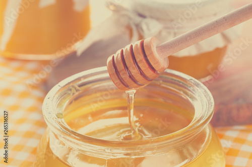 Honey background. Sweet honey in glass jar on wooden background.