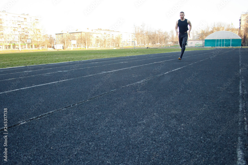 one caucasian male is doing a sprint start. running on the rubber track. Track and field runner in sport uniform. energetic physical activities. outdoor exercise, healthy lifestyle