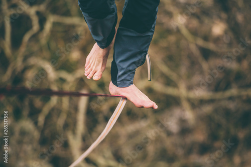 A man is walking along a stretched sling.