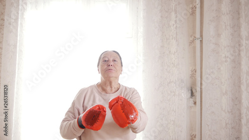 Portrait of old senior woman in boxing gloves