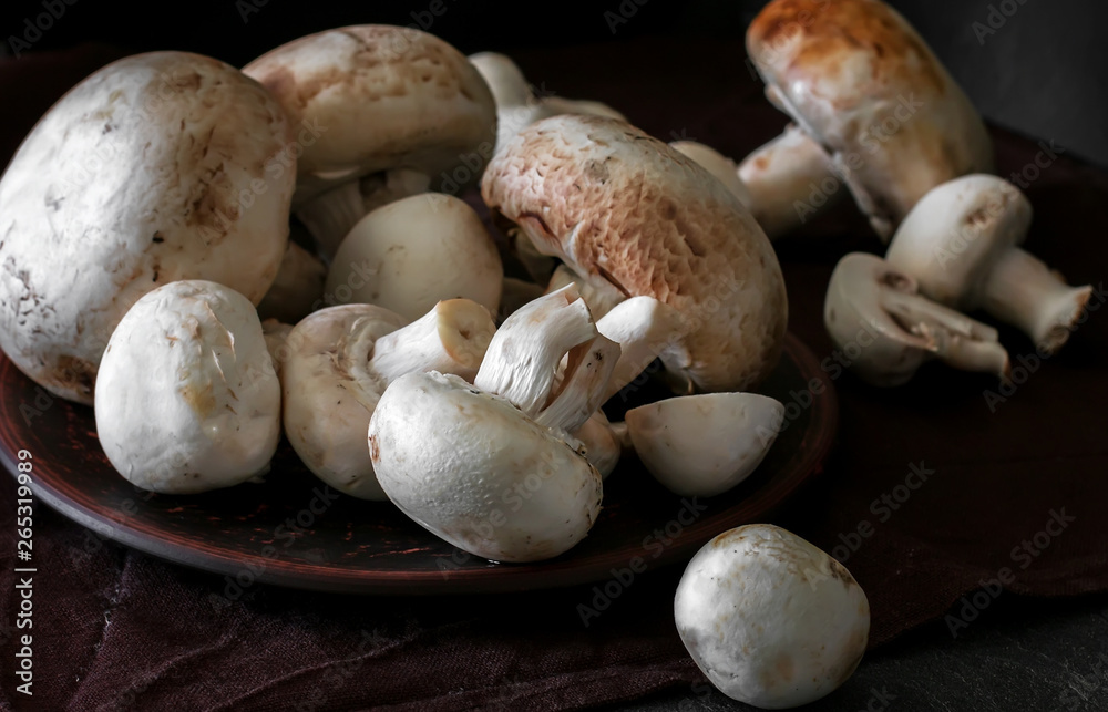 Fresh champignon mushrooms group on the table. Fresh vegetables mushrooms - the concept of healthy proper nutrition. Dark Food Photography Fresh champignon mushrooms group on the table. Fresh vegetables mushrooms - the concept of healthy proper nutrition. Dark Food Photography