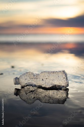A plastic bottle floating in the sea in a beach with dirty coast
