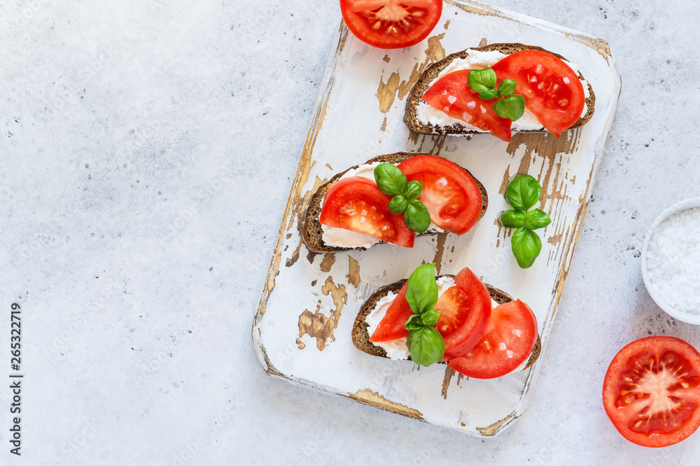Toasted bread with tomatoes, ricotta (cream cheese), basil
