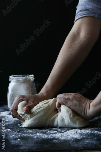 Person kneading dough with flour