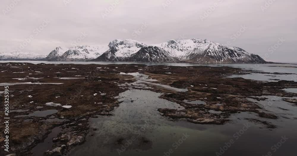 Drone fly over frozen wetlands with mountain range in the background in beautiful Lofoten Norway Drone fly over frozen wetlands with mountain range in the background in beautiful Lofoten Norway