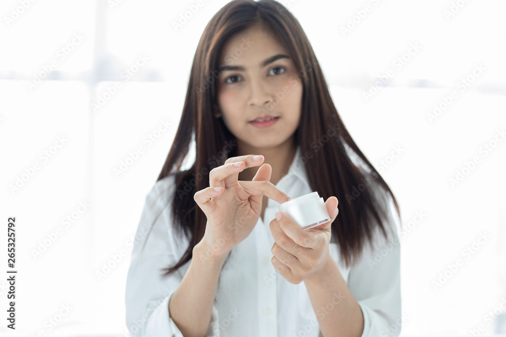 A beautiful woman asian using a skin care product, moisturizer or lotion taking care of her dry complexion. Moisturizing cream in female hands . A beautiful woman asian using a skin care product, moisturizer or lotion taking care of her dry complexion. Moisturizing cream in female hands .