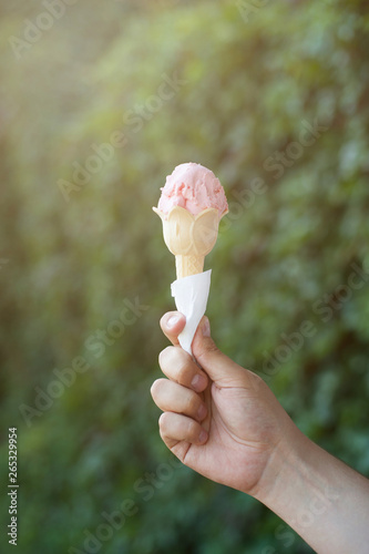 Hand holding a pink ice cream. Summer warm picture