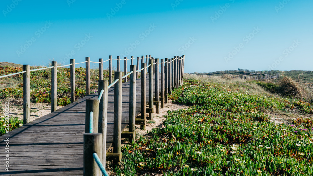 Wooden boardwalk at the Praia da Frente Azul, in english the blue beach front in the seaside resort Espinho Wooden boardwalk at the Praia da Frente Azul, in english the blue beach front in the seaside resort Espinho
