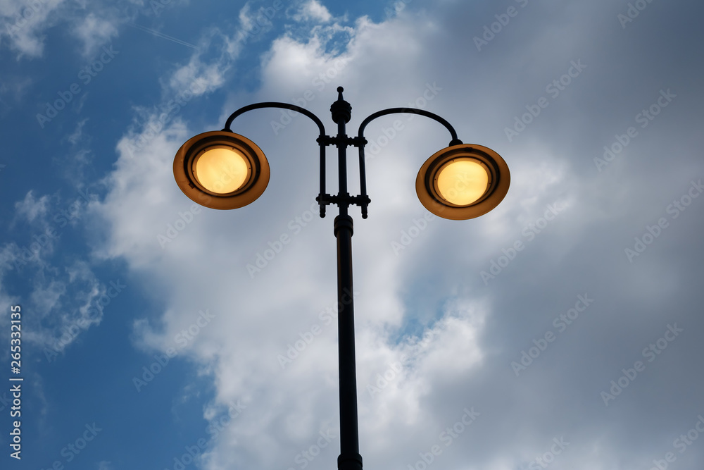 city lit light pole on day with cloudy sky city lit light pole on day with cloudy sky