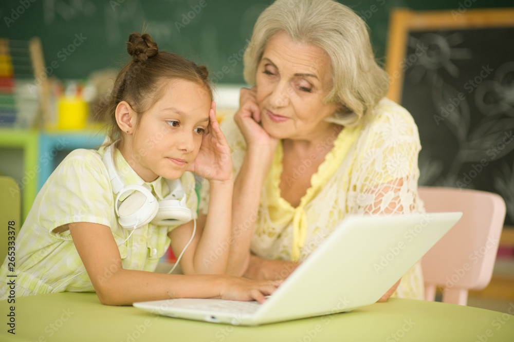 Grandmother and daughter using modern laptop at home Grandmother and daughter using modern laptop at home