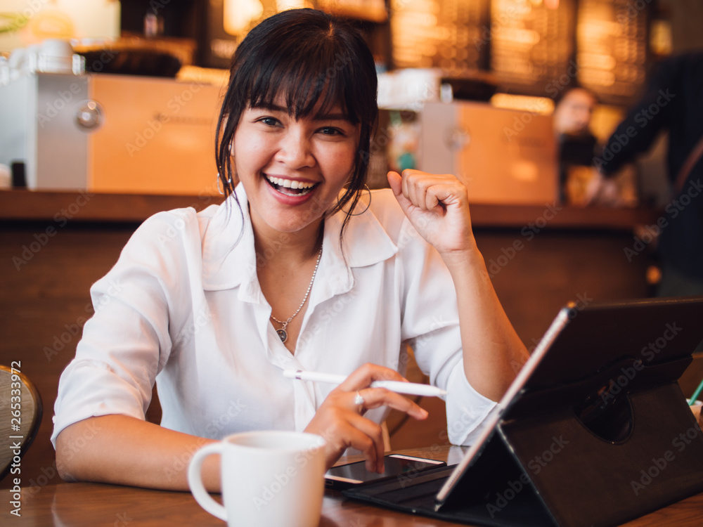 Asian woman drinking coffee in cafe and using laptop computer for working business online marketing Asian woman drinking coffee in cafe and using laptop computer for working business online marketing
