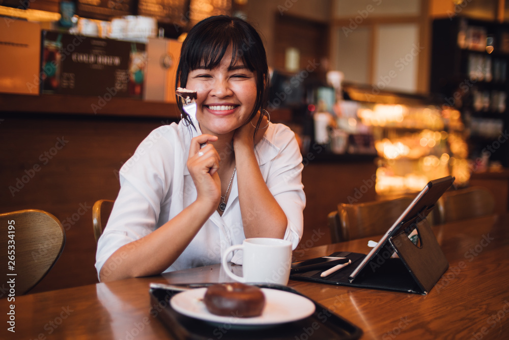 Asian woman drinking coffee in cafe and using laptop computer for working business online marketing