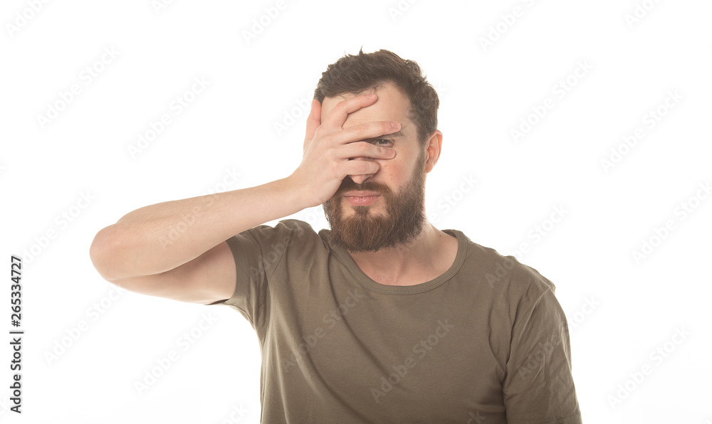 Portrait of a scared man covering his face with palm and looking at camera through fingers isolated on a white background Portrait of a scared man covering his face with palm and looking at camera through fingers isolated on a white background