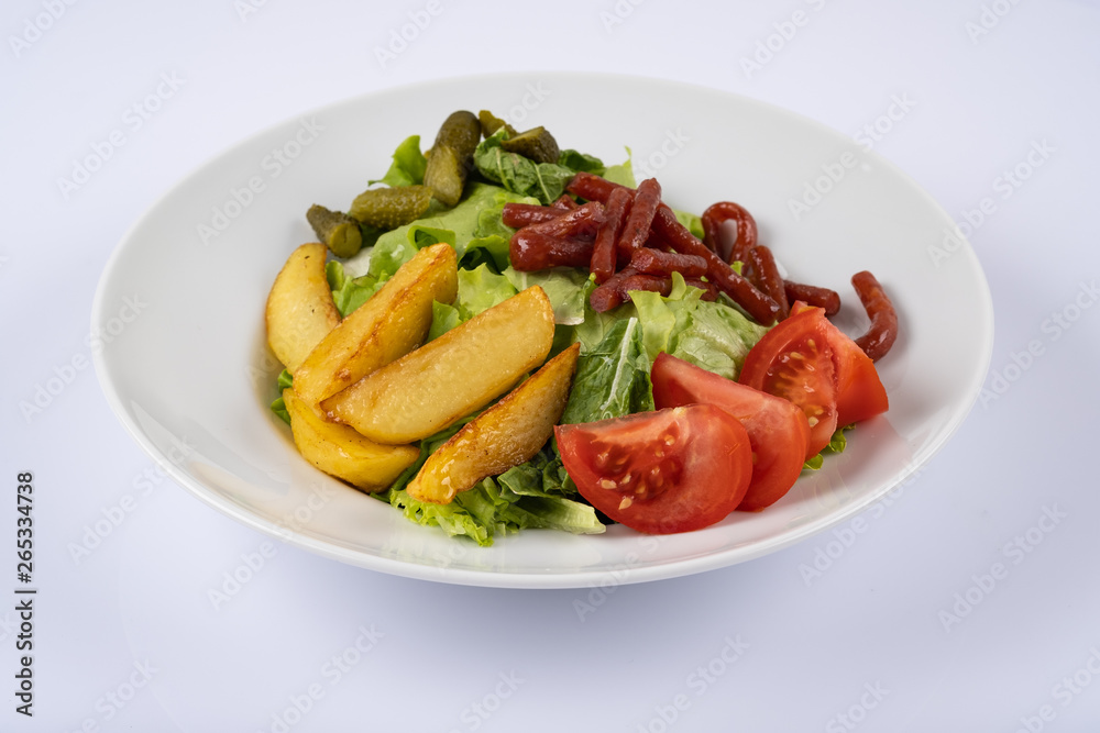 Grilled sausages, baked potatoes and vegetables on white plate Grilled sausages, baked potatoes and vegetables on white plate