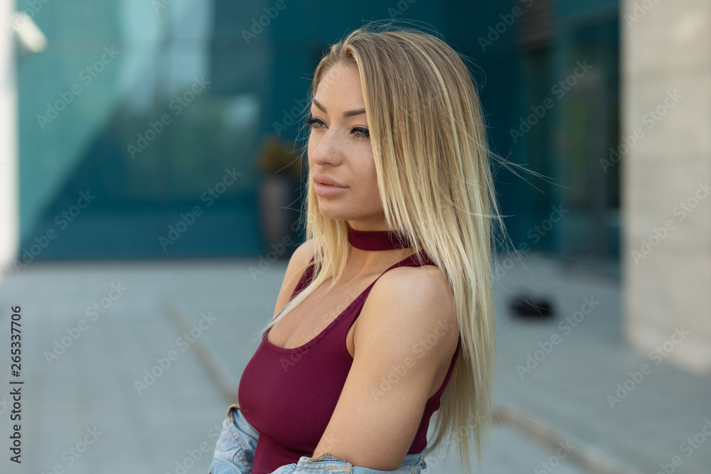 Beautiful smiling girl outdoor. A portrait of a beautiful blonde young Caucasian woman outdoor.