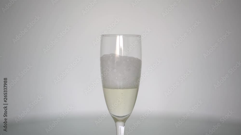 foam quickly settles into a glass of champagne foam quickly settles into a glass of champagne