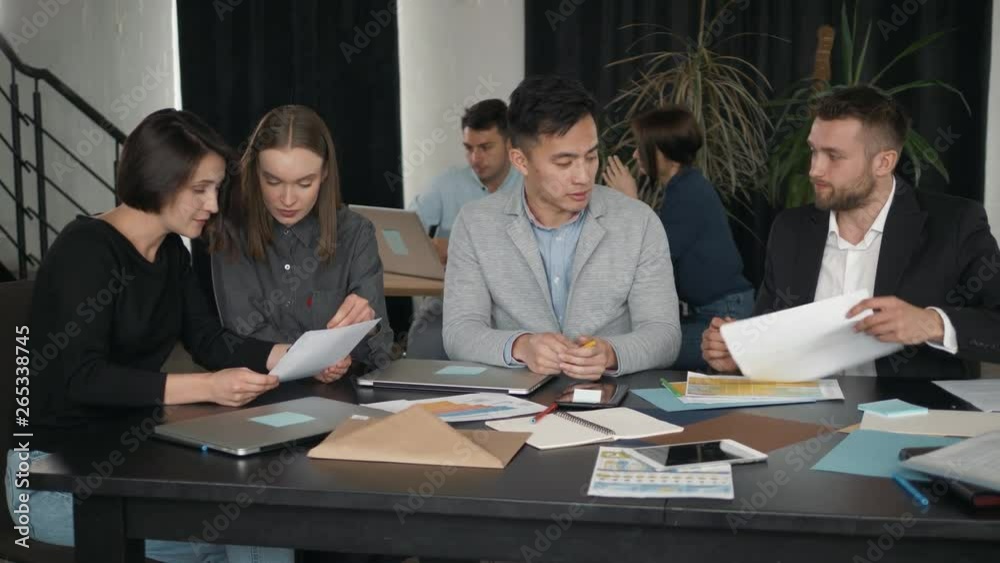 Group of a young coworkers dressed casually working together with laptops in the modern office coworking students university Group of a young coworkers dressed casually working together with laptops in the modern office coworking students university