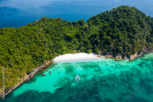 Aerial drone view of a tropical beach on a green  deserted island