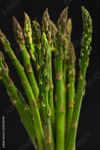 Bunch of fresh asparagus on a black background. Selective focus. 