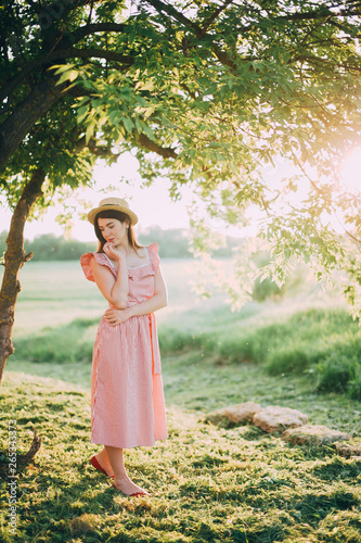 beautiful girl in a hat and red dress posing in nature. sunset © Dmitriy Shipilov