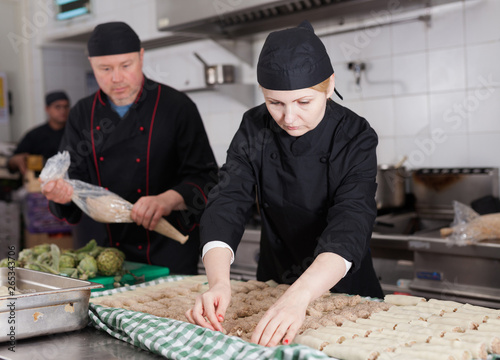 Female cook preparating cannelloni photo