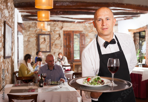 Waiter holding tray with dish photo