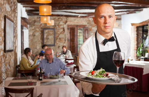 Waiter in white shirt holding tray