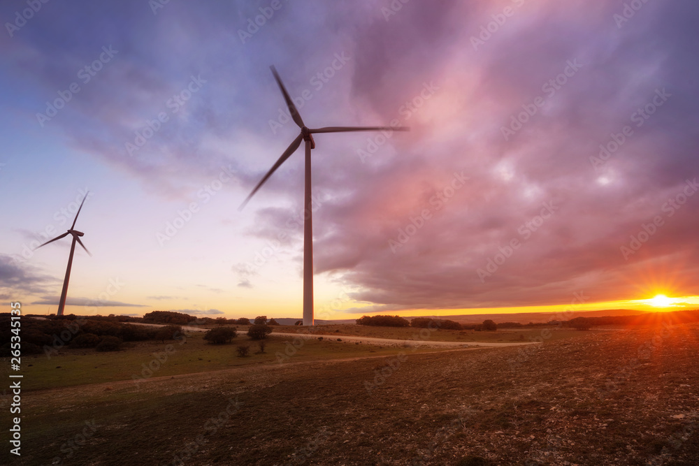 wind turbines silhouette on mountain at sunset .
