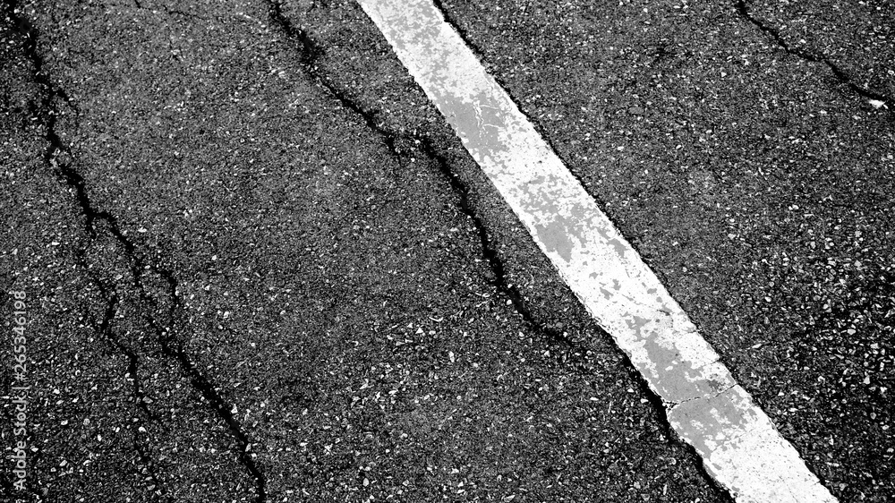 Fototapeta premium crack and texture of asphalt road with white dashed line top view background.
