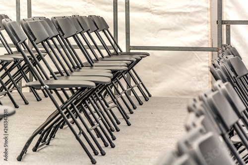 Fotografi Rows of black folding chairs empty