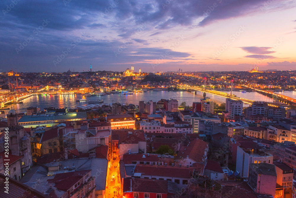 Scenic night view of Istanbul from Galata tower (Kulesi). Panoramic cityscape with city lights and color sunset glow sky, Turkey. Travel background