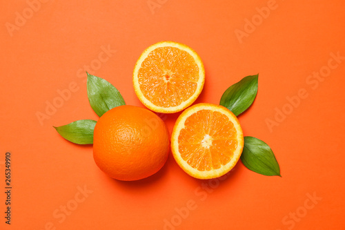 Ripe oranges and leaves on color background. Space for text